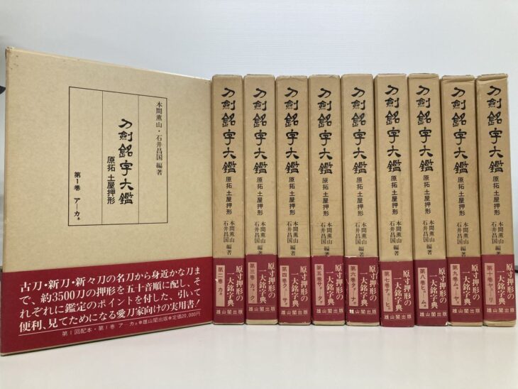 薄茶色の函に赤い帯が巻かれた雄山閣出版『刀剣銘字大鑑 原拓 土屋押形』第1巻から第10巻の10冊
