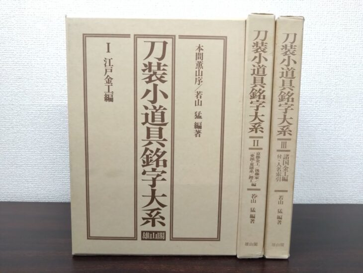 薄いベージュの函に茶色の文字で書名が入った雄山閣『刀装小道具銘字大系』I・II・IIIの3冊