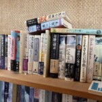 めるくまーる社『瞑想 祝祭の芸術』『一休道歌』上下、市民出版社『奇跡の探求』I、瞑想社『秘教の心理学』などが1段に並ぶ木の書棚