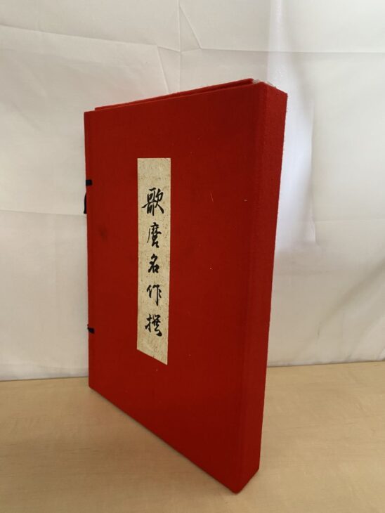 筆文字で「歌麿名作撰」と入った題箋が貼られた悠々洞出版の赤い布張りの帙