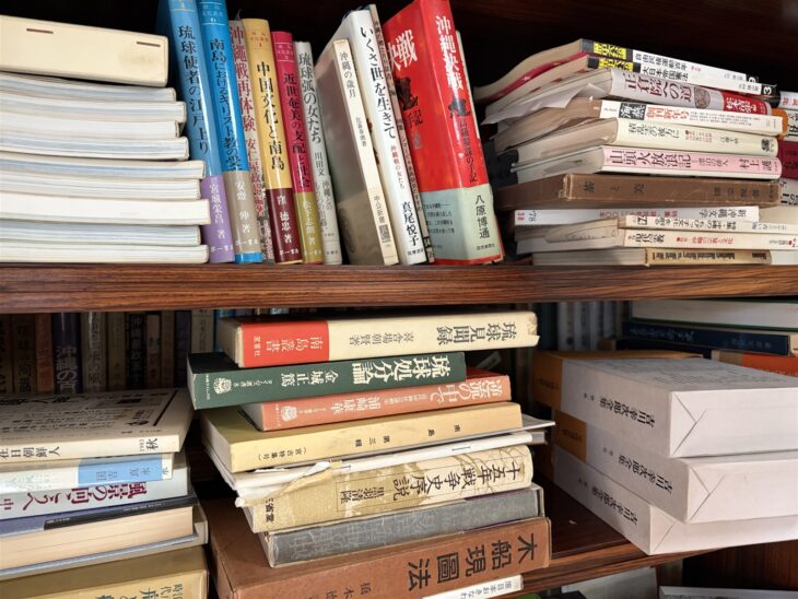 上段に『沖縄決戦 高級参謀の手記』と『いくさ世を生きて』、下段に『琉球見聞録』『琉球処分論』『十五年戦争史序説』が重なる本棚