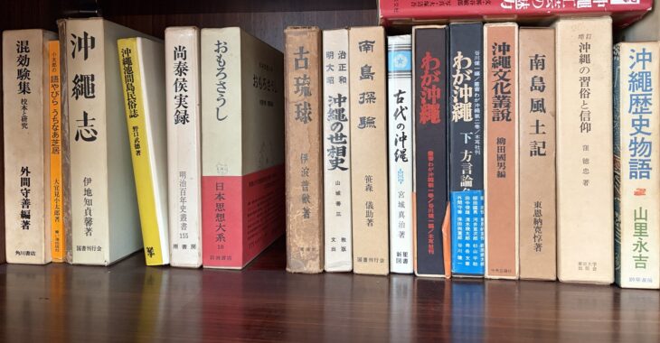 『混効験集』『沖縄志』『おもろさうし』『古琉球』『南島探験』『沖縄文化叢説』『南島風土記』が並ぶ木の本棚の一段