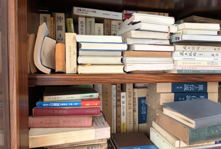 上段に『沖縄志』『尚泰侯実録』『おもろさうし』、下段に『八重山語彙』『私観太平洋戦争』と『旅と伝説』の合本が並ぶ本棚