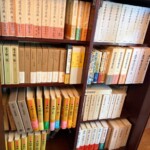 潁原退蔵著作集と中野好夫集、大田南畝全集、黄色の背の日本民俗文化大系が段ごとに並ぶガラス戸の書棚
