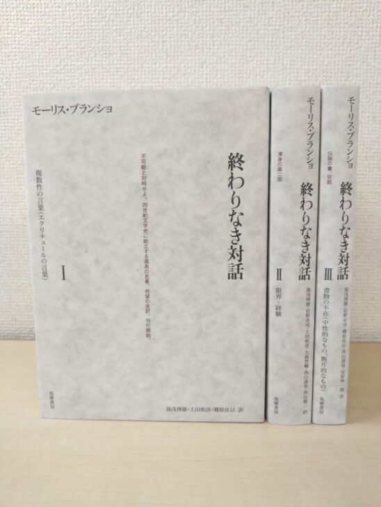 筑摩書房『終わりなき対話』の3冊。左の第Ⅰ巻は灰色のまだら模様の表を見せ、右の第Ⅱ巻と第Ⅲ巻は背に「限界-経験」「書物の不在」の巻名と訳者名
