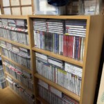 木の棚2本にクラシックのCDが詰まり、右の棚の上段に伊福部昭『百年紀ベスト』『作品集』と冨田勲『宇宙幻想』の背