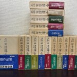 花田清輝全集の函17冊。下に第1巻から第12巻の函、上に第13巻から別巻2の函を積み、帯に復興期の精神 二つの世界 大衆のエネルギーなどの巻名