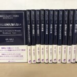 ナチュラルスピリット『奇跡のコース』のワークを学ぶガイドブック13冊。帯付きの第1巻『わたしは何も知らない』の表紙と、濃紺の背に白い字で巻名が入った第2巻から第13巻