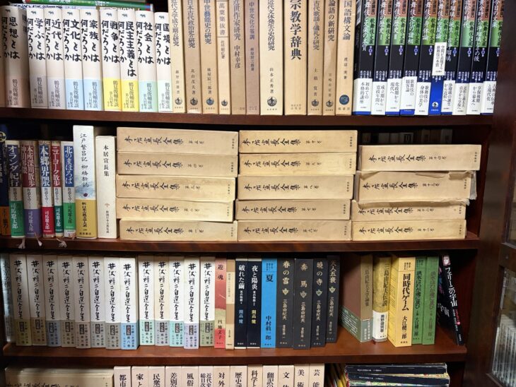 筑摩書房『本居宣長全集』の函14箱、新潮社『井伏鱒二自選全集』13冊、晶文社『鶴見俊輔座談』、岩波講座『歌舞伎・文楽』が並ぶ木の書棚