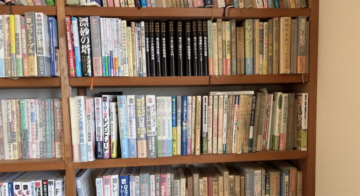 大沢在昌『漂砂の塔』、川崎さちえ『投資の達人探訪』、同友館『林輝太郎相場選集』の黒い背が並ぶ本棚の2段