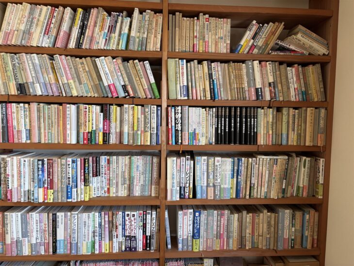 『相場のこころ』『確率論的思考』『ウイニングエッジ』『オプション売買の実践』など株とFXの本が何段にも並ぶ木の本棚