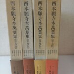 主婦の友社『西本願寺本萬葉集(普及版)』の函4つ。薄茶色の背に書名と巻第一から巻第二十までの巻数、下に茶、赤茶、黄土色、朱の帯と「発行 主婦の友社 総発売元 おうふう」の文字