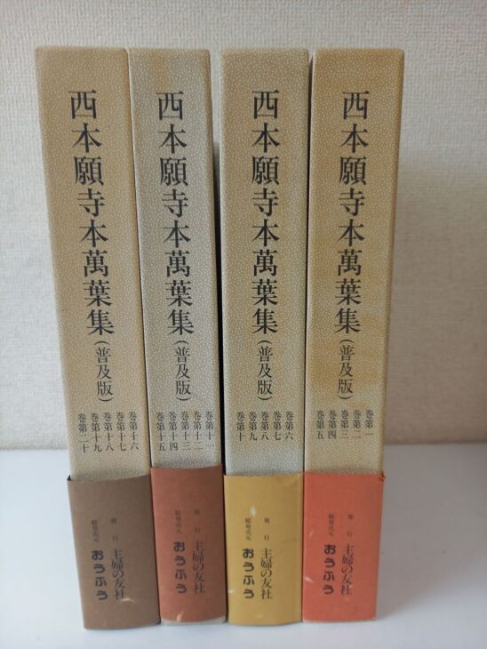 主婦の友社『西本願寺本萬葉集(普及版)』の函4つ。薄茶色の背に書名と巻第一から巻第二十までの巻数、下に茶、赤茶、黄土色、朱の帯と「発行 主婦の友社 総発売元 おうふう」の文字