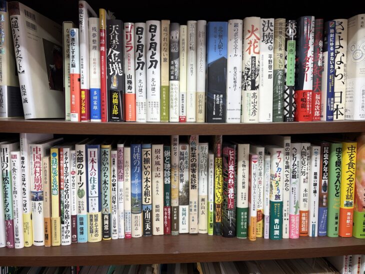 高橋五郎『天皇の金塊』、山極寿一『ゴリラ』、西岡常一『木のいのち木のこころ』、三橋淳『虫を食べる人びと』、梅谷献二『虫を食べる文化誌』が並ぶ本棚の2段