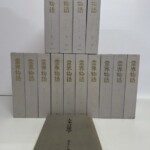 灰色の布装の霊界物語が2段に並び、背に金の字で霊界物語 出口王仁三郎と1から14の番号。手前に大本言霊学の薄い1冊