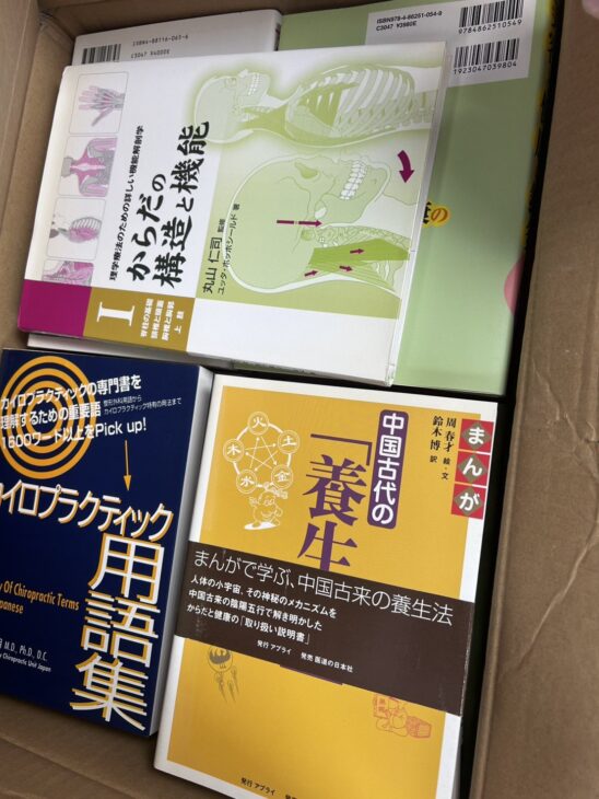 丸山仁司 監修『からだの構造と機能 I』、『カイロプラクティック用語集』、『まんが 中国古代の養生法』が入った段ボール箱