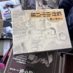 千葉伸夫 編『監督 山中貞雄』の函と、井上和男 編『小津安二郎全集』、吉村公三郎『映画監督 書く、語る』が積まれた本の山の上