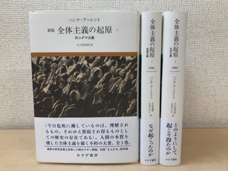 みすず書房『全体主義の起原』新版3冊。第1巻の表紙に群衆の白黒写真と帯、第2巻と第3巻は背を見せて並ぶ